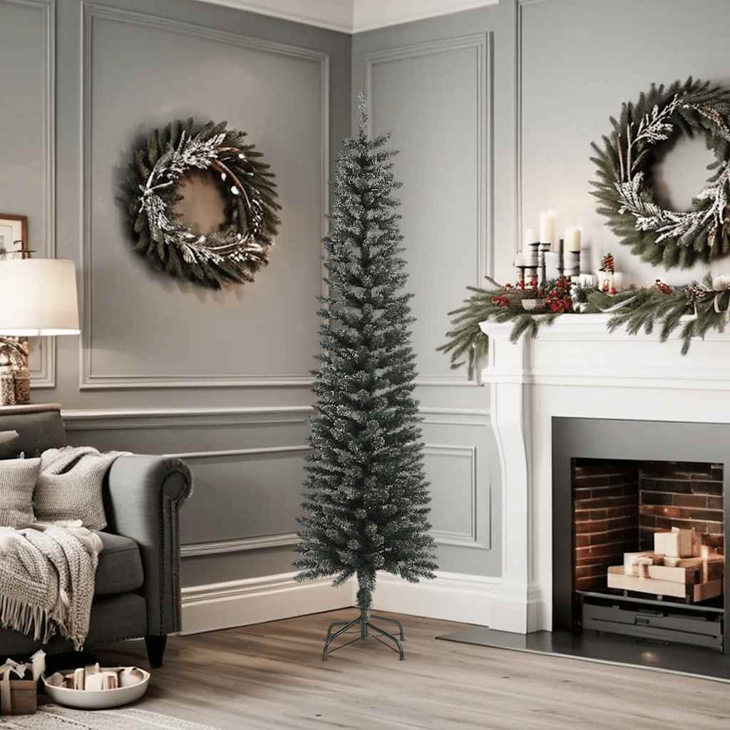 A 6 ft slim artificial Christmas tree with green PVC branches dusted in snow, standing on a steel base in a cozy gray living room.
