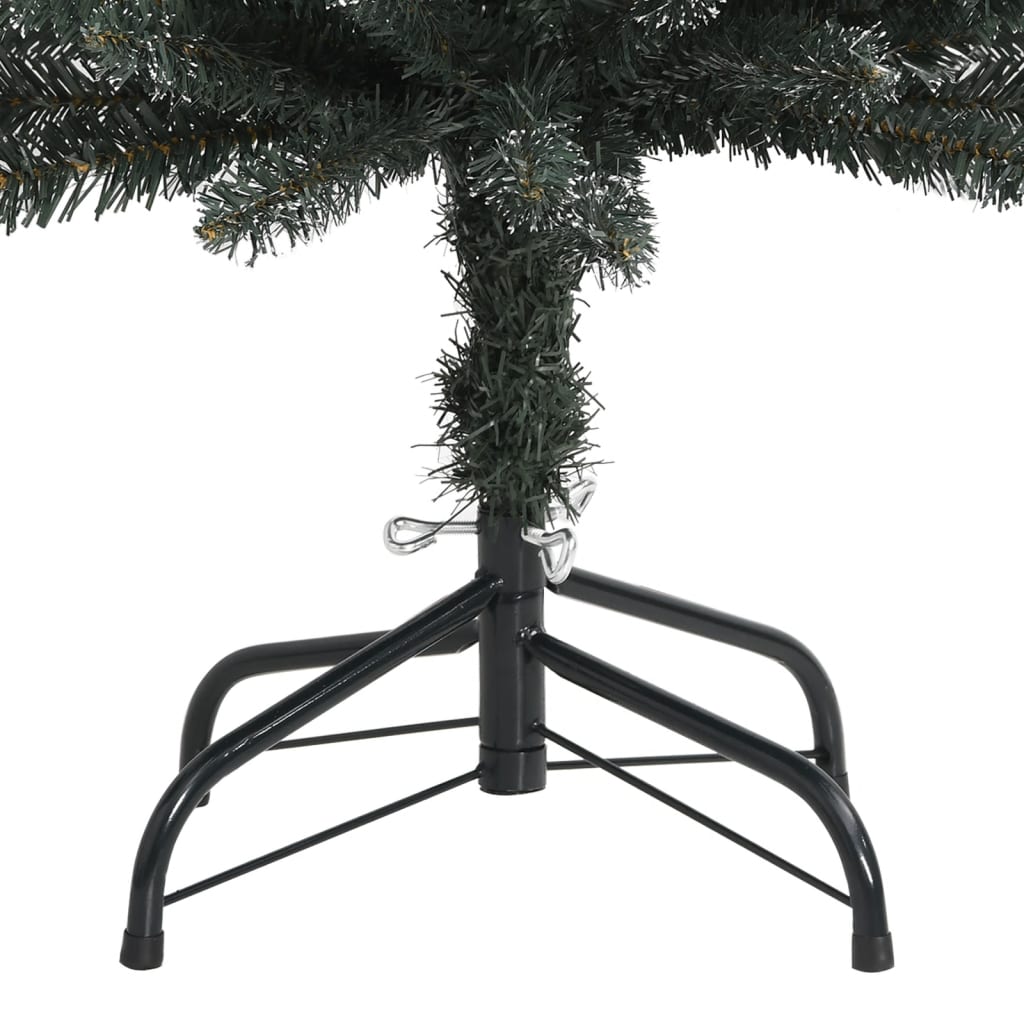 7ft slim artificial Christmas tree in green PVC with snow, on black metal stand.