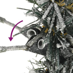 Close-up of flocked snow-covered branches on a slim 7ft artificial Christmas tree.