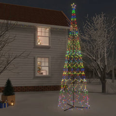 A 26ft tall cone-shaped Christmas tree with 3000 colorful LEDs, lit up at night beside a snowy house.