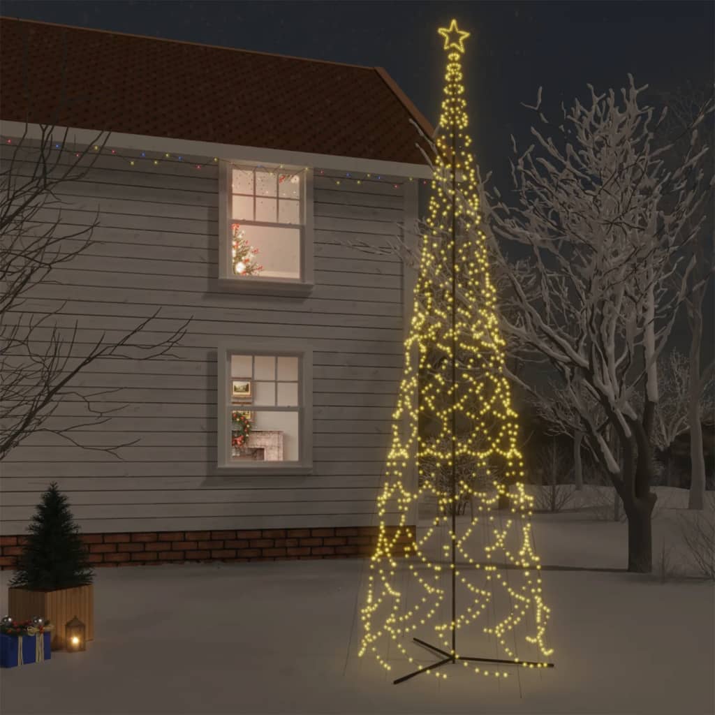 A 26ft tall warm white LED Christmas cone tree with 3000 lights, standing in a snowy yard at night.