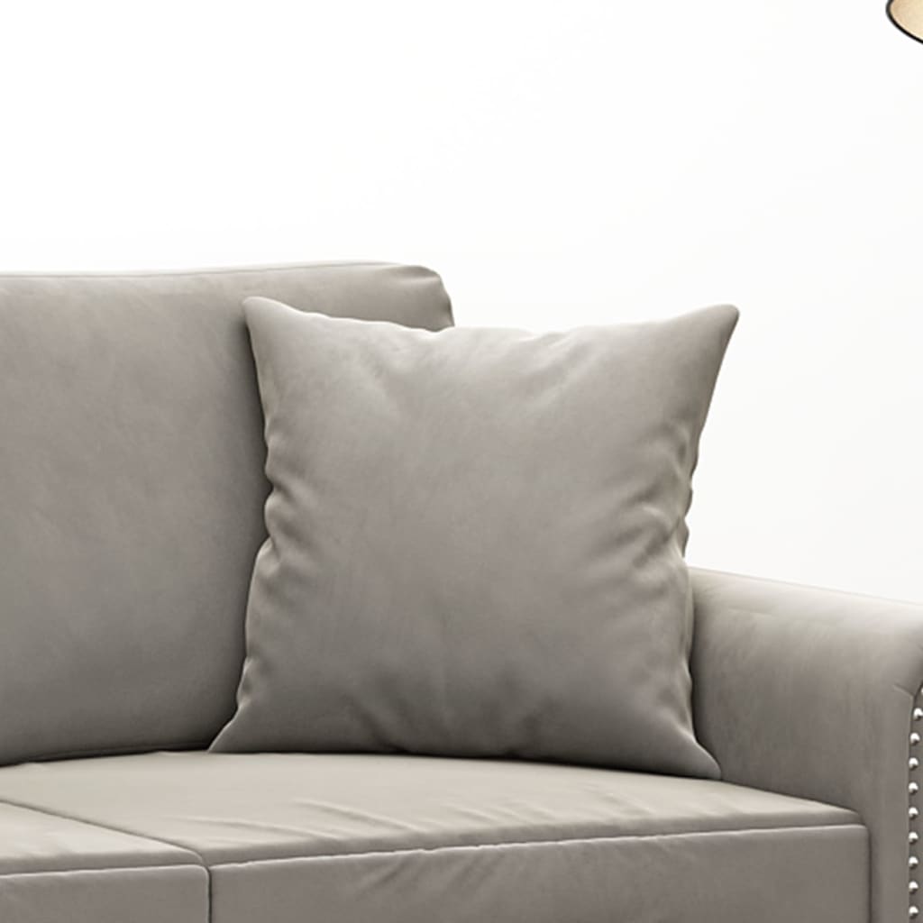 A set of two light gray velvet throw pillows, each 15.7 inches square, on a gray sofa.