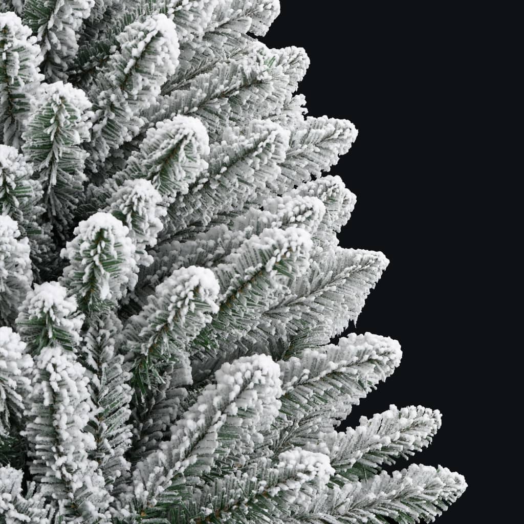 Green artificial hinged Christmas tree with white flocked snow on branches and metal stand.