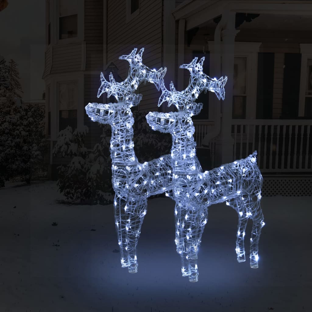 Two 39.4-inch tall acrylic LED reindeer Christmas decorations glowing with white lights on a snowy porch.