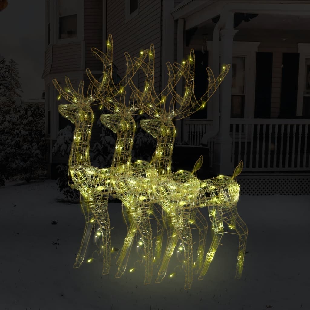 Three lighted acrylic reindeer decorations with warm white LEDs on a snowy porch.