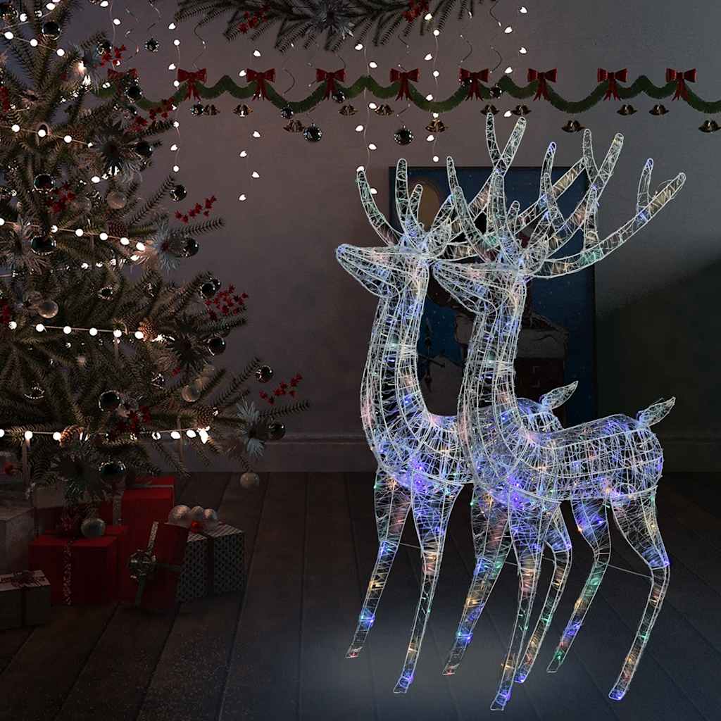 Two 70.9-inch acrylic reindeer silhouettes with 250 multicolor LEDs, lit up beside a Christmas tree.