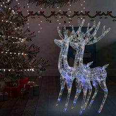 Two 70.9-inch acrylic reindeer silhouettes with 250 multicolor LEDs, lit up beside a Christmas tree.