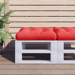 Two red square pallet cushions sit on a white pallet bench on a wooden deck.
