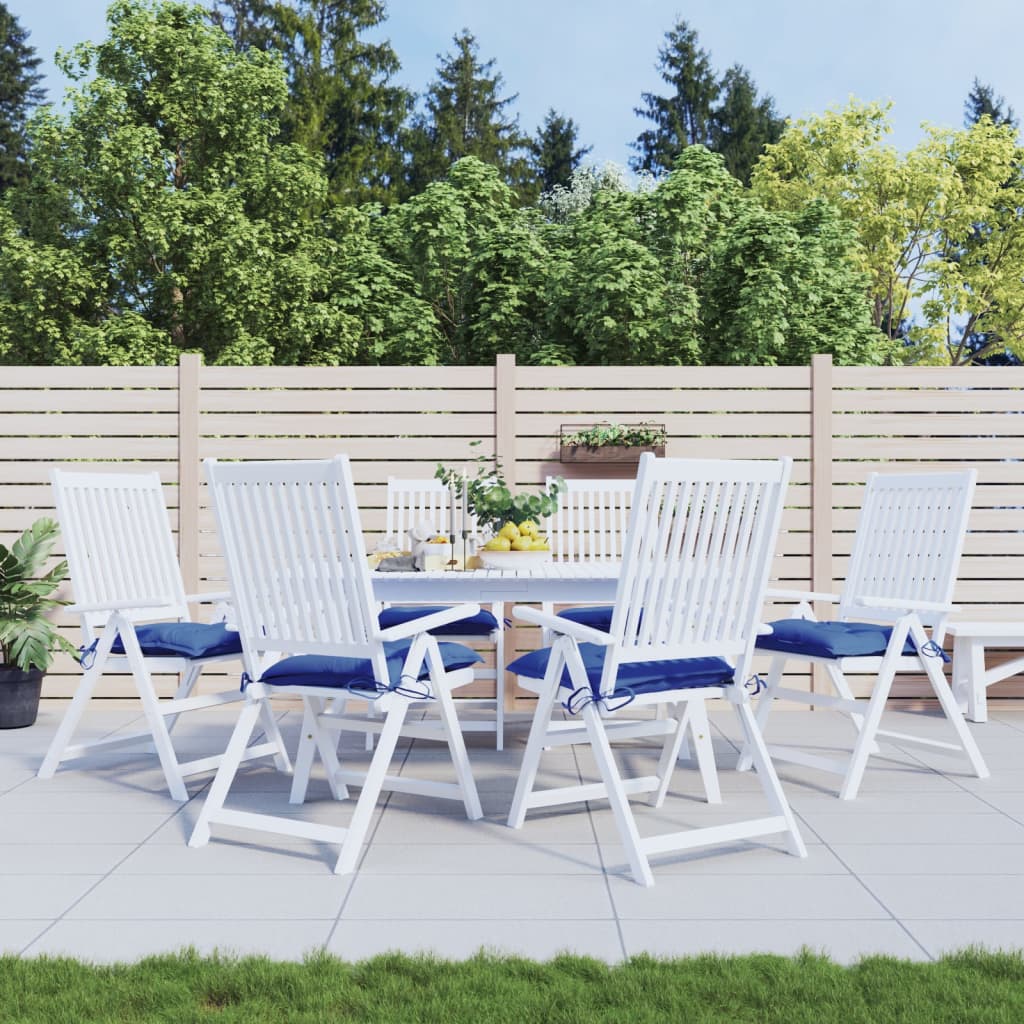 White outdoor dining table with six chairs, each with blue Oxford fabric cushions.