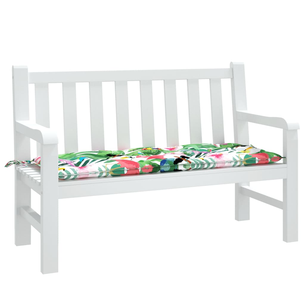 White garden bench with a multicolor fabric cushion featuring tropical leaf patterns.