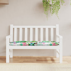 White garden bench with multicolor floral cushion featuring birds and leaves.