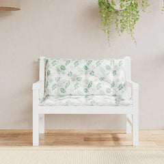 Two green leaf-patterned cushions on a white wooden garden bench.