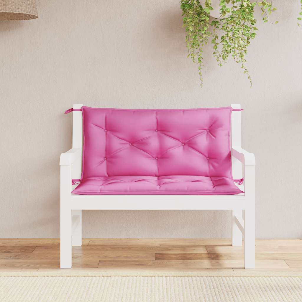 Two pink outdoor garden bench cushions with tufted design and tie straps on white bench.
