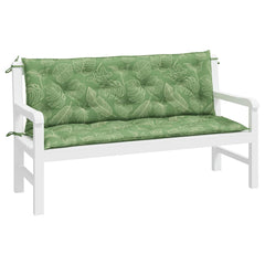 White garden bench with two green leaf-patterned cushions and ties.