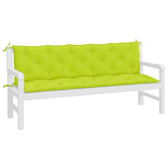 A white wooden garden bench with bright green tufted cushions attached via ropes.