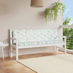 Two green leaf-patterned Oxford fabric bench cushions on a white garden bench.
