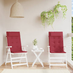 Two wine red Oxford fabric cushions on white highback chairs on a balcony.