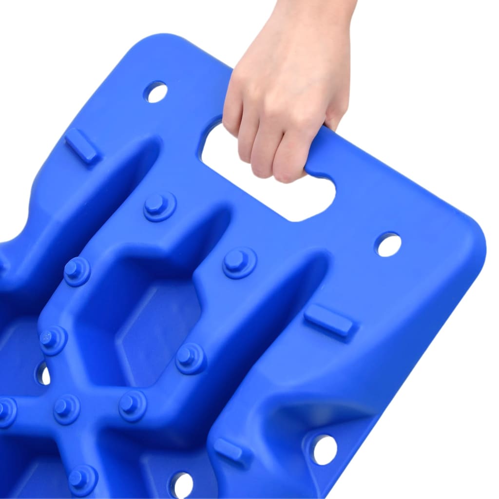A hand holds a blue nylon traction board with grip teeth and handles from a 2-pack.