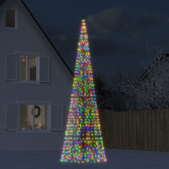 Tall LED Christmas tree with colorful lights in front of a house at night.