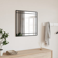 A black square wall mirror with iron frame, 19.7x19.7 inches, hung in a light room.