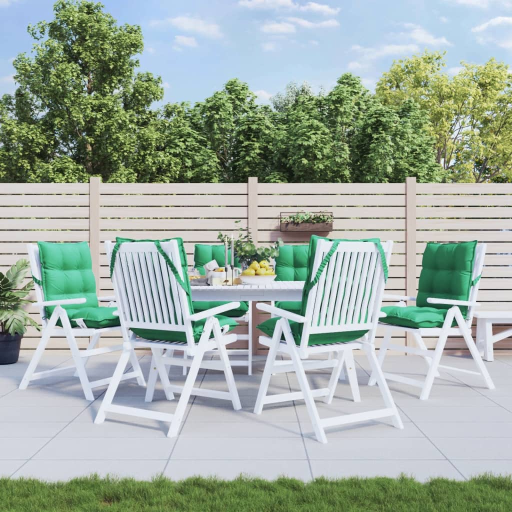 Six green Oxford fabric lowback chair cushions with ties, displayed on white patio chairs around a table in a garden.