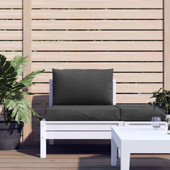 Two anthracite melange polyester cushions on a white pallet sofa with plants and table.