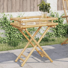 Bamboo folding tray table with slatted top, holding a plant and book, on a patio.