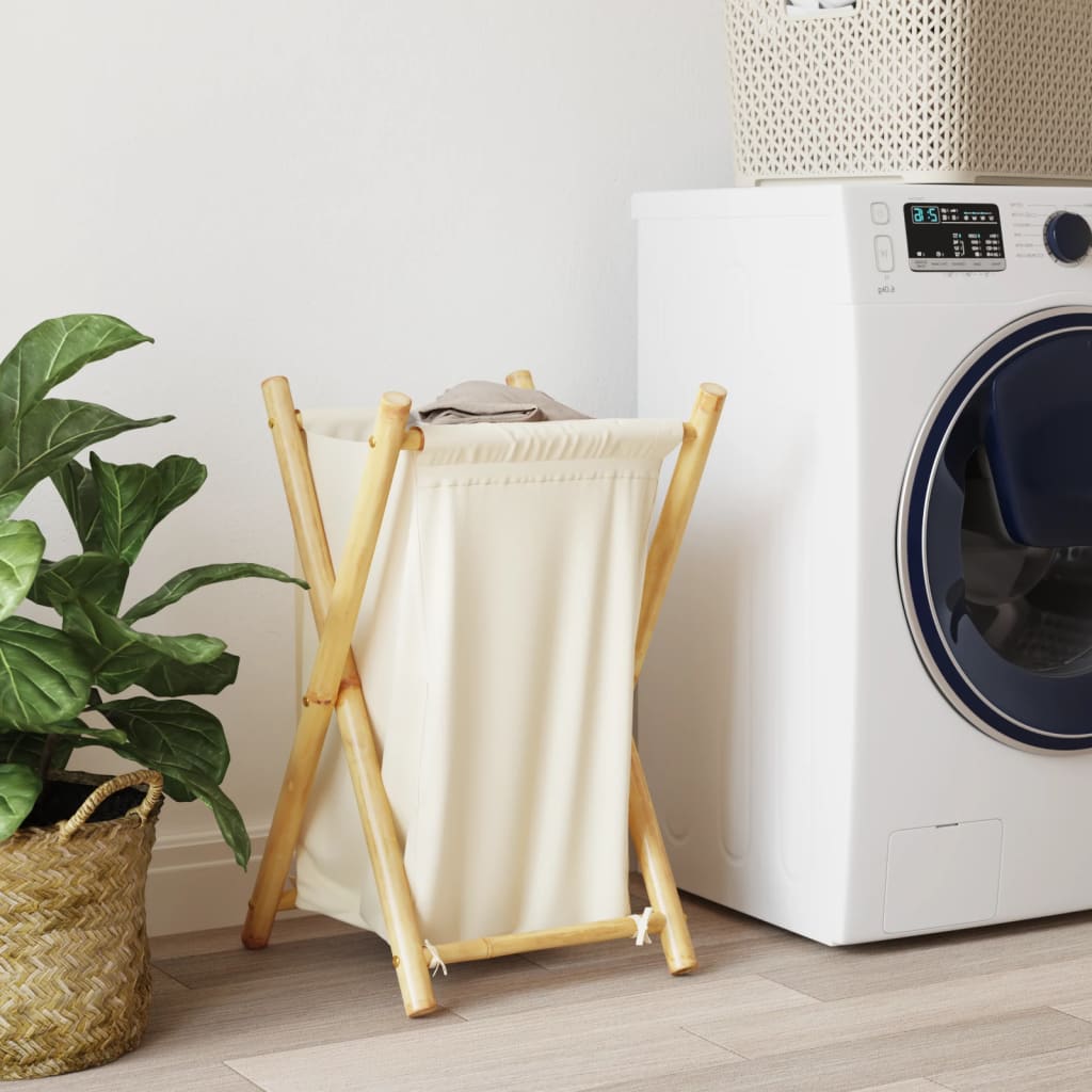 Cream white bamboo laundry basket with foldable frame next to a white washer.