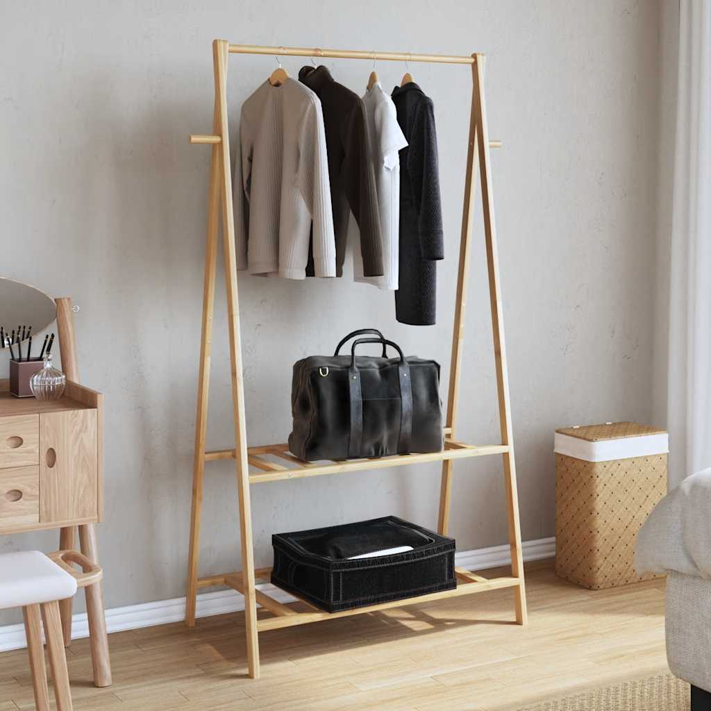 Bamboo clothes rack with hanging rod, two shelves, and hooks in a bedroom.