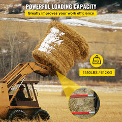 Red coated 32-inch hay bale spear attached to a loader lifting a large hay bale with snow.