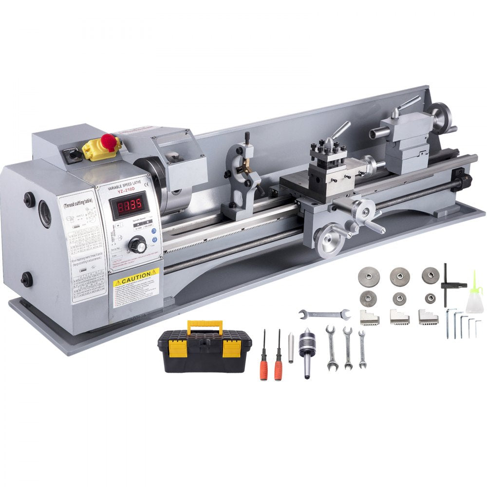 A gray mini metal lathe with a digital display and various tools laid out beside it.