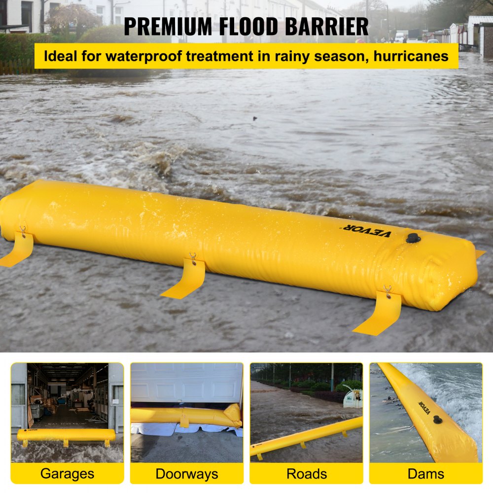 A yellow 12 ft reusable PVC flood barrier tube with D-rings, deployed on a driveway.