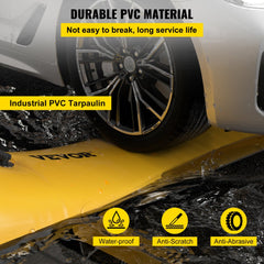 Yellow PVC flood barrier tube on driveway, labeled with durable, waterproof, anti-scratch features.