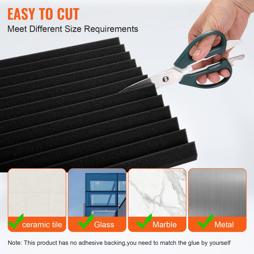 Hand cutting black acoustic foam panels with scissors for soundproofing walls.