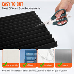 Hand cutting black acoustic foam panels with scissors for soundproofing walls.