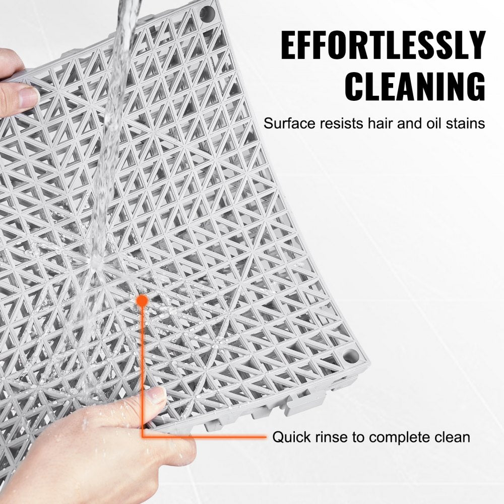 Gray PVC interlocking drainage tiles, 12"x12", designed for efficient water flow and slip prevention.