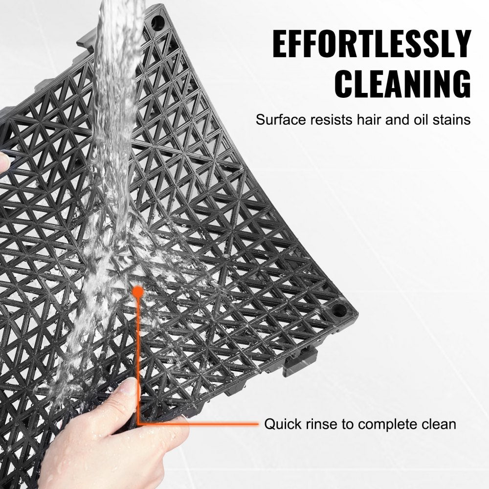 Black PVC interlocking drainage floor tile with water running over textured surface and hand holding it.