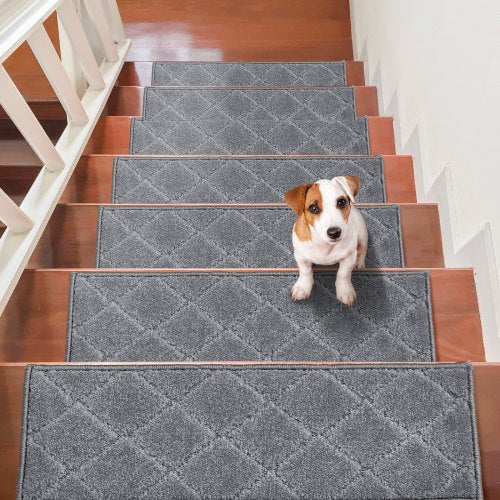 Gray non-slip stair treads installed on wooden steps with a Jack Russell terrier sitting on one.