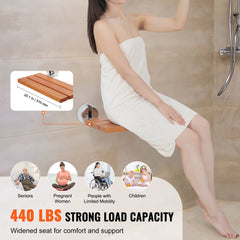 A woman sits on a 20.1-inch folding teak shower seat with a 440 lbs capacity.