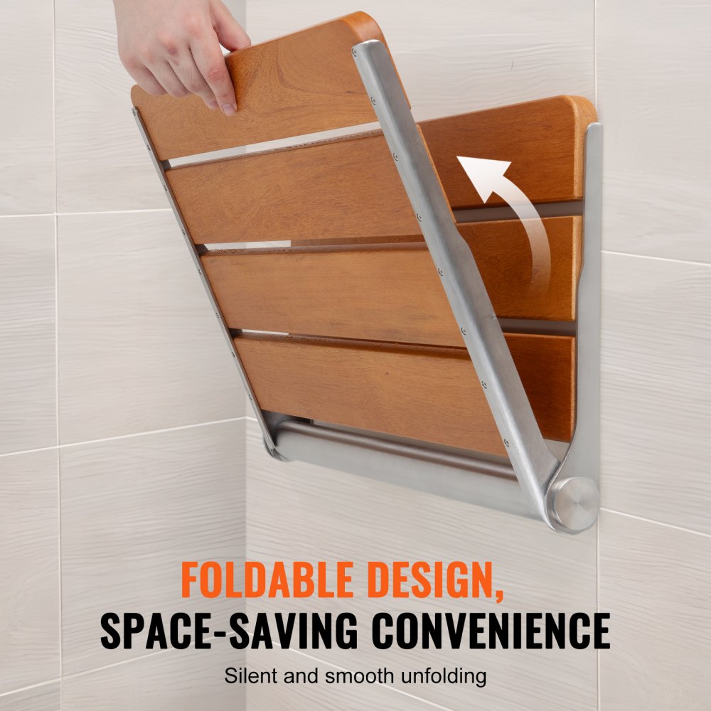 A person's hand is shown unfolding a wall-mounted teak shower seat with a metal frame.