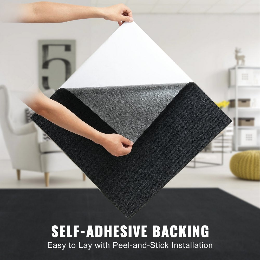 Hands peeling back corner of black self-adhesive carpet tile in a living room setting